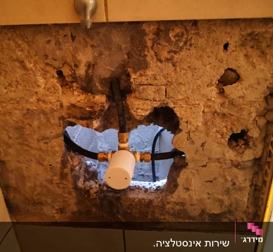 צינור מים עם מחבר בקיר חשוף